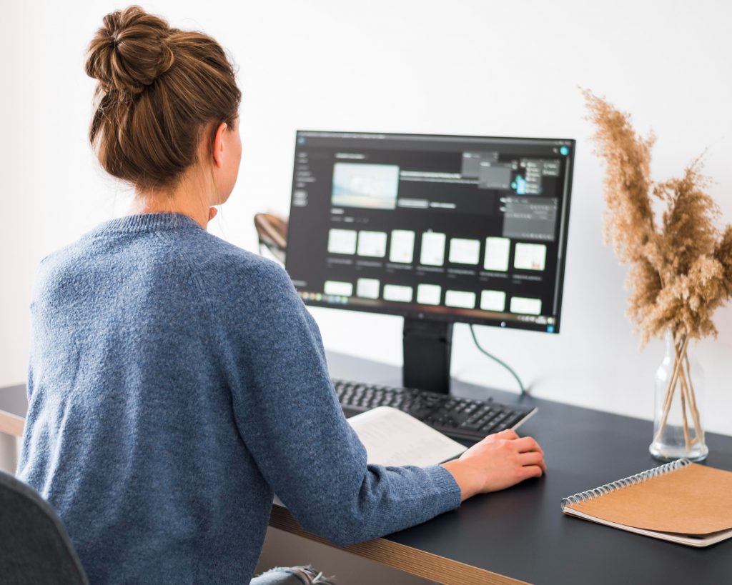 девушка за компьютером создает женский сайт на конструкторе, который входит в тариф хостинга